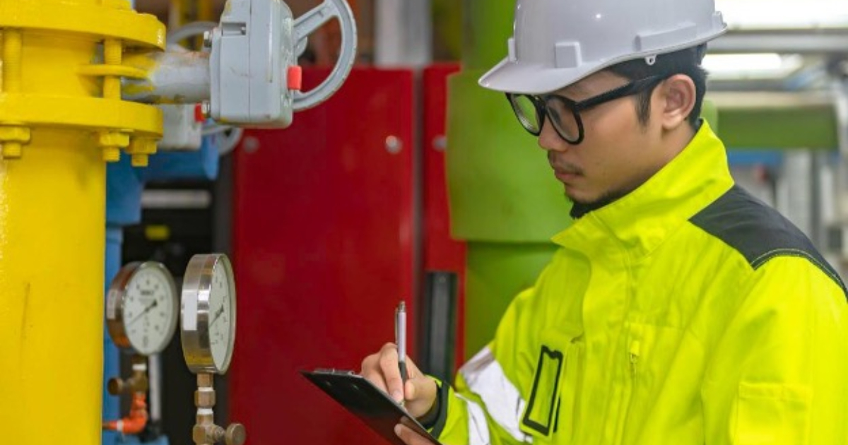 Facility engineer reviewing an industrial steam boiler installation checklist on site